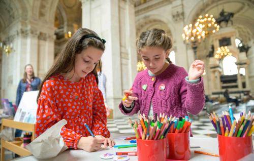 Two young children making badges inside St Paul's Cathedral