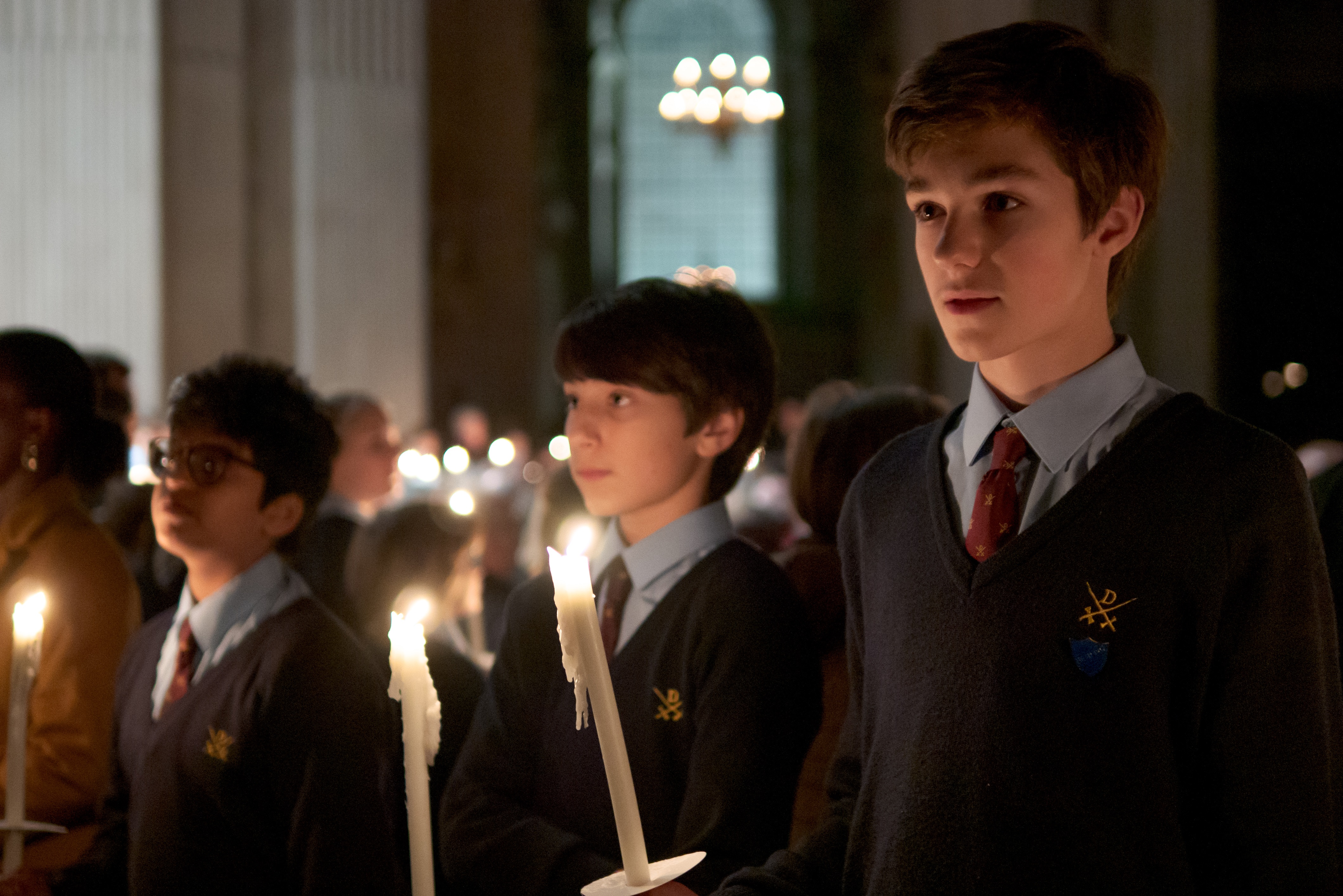 Group of school boys holding candles in the cathedral