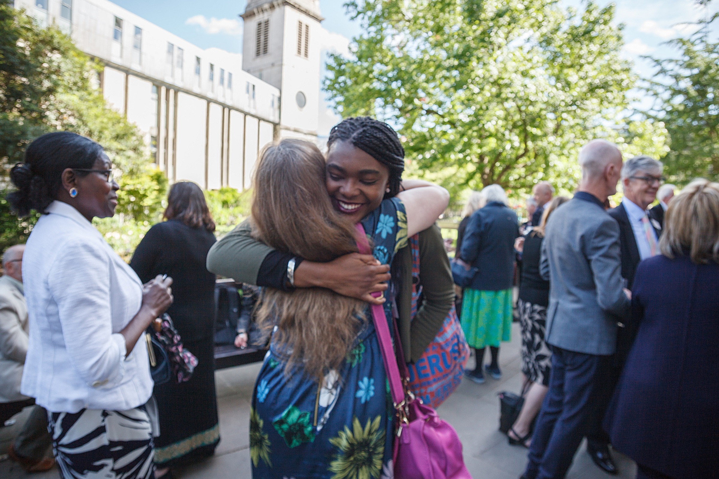 volunteer freinds hug sun churchyard