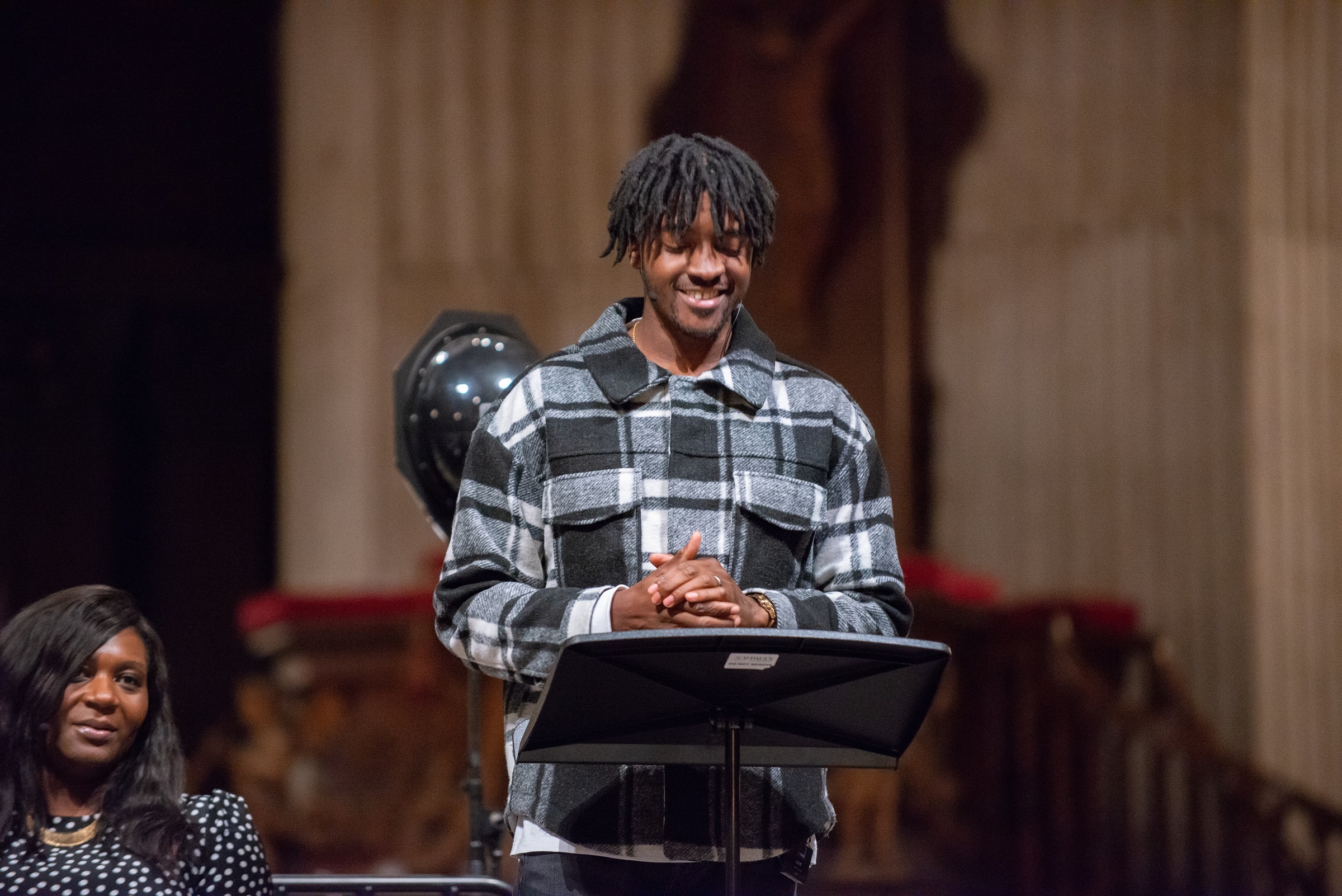 young black man speaking at pulpit as part of special service