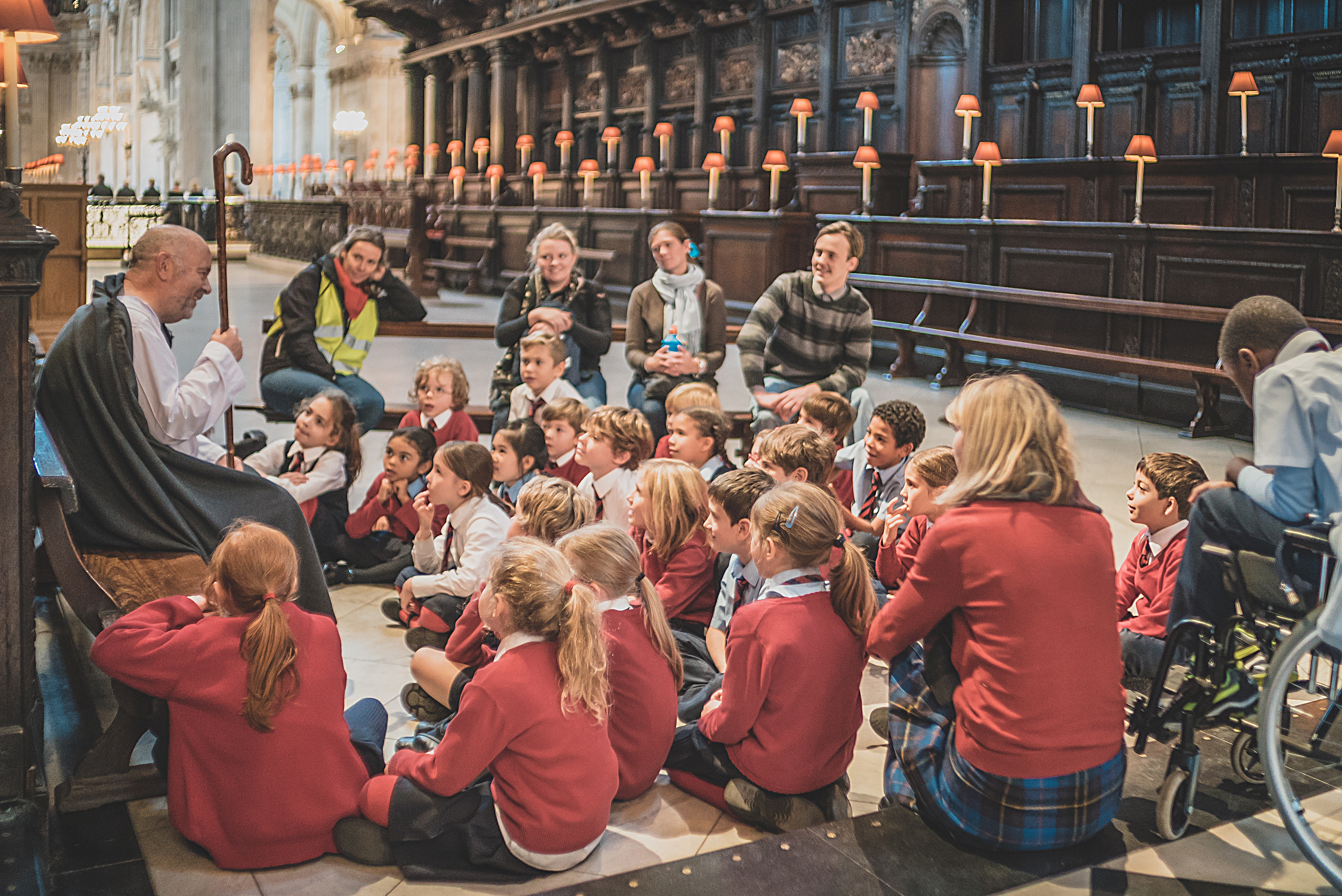 Primary school children sitting on the floor in the quire of St Paul's