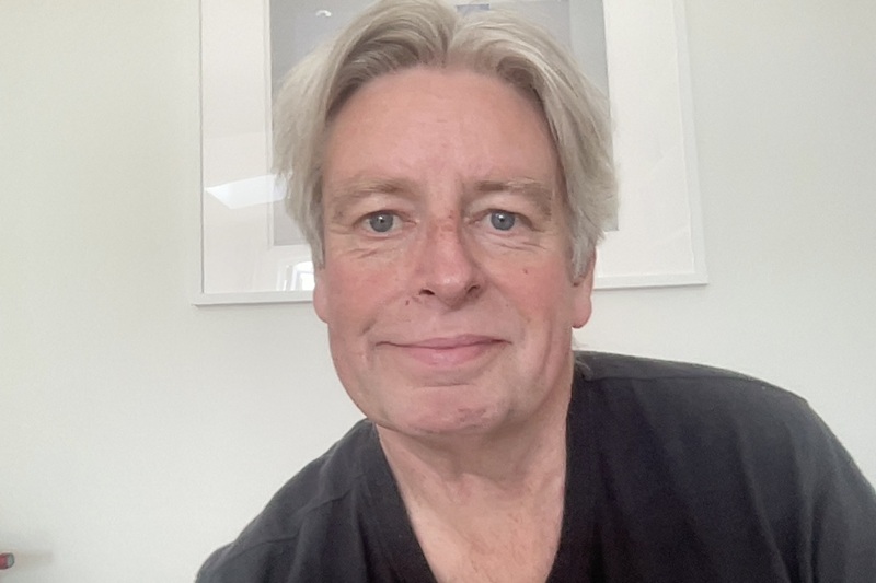 Graeme has short grey hair and wears a black tshirt