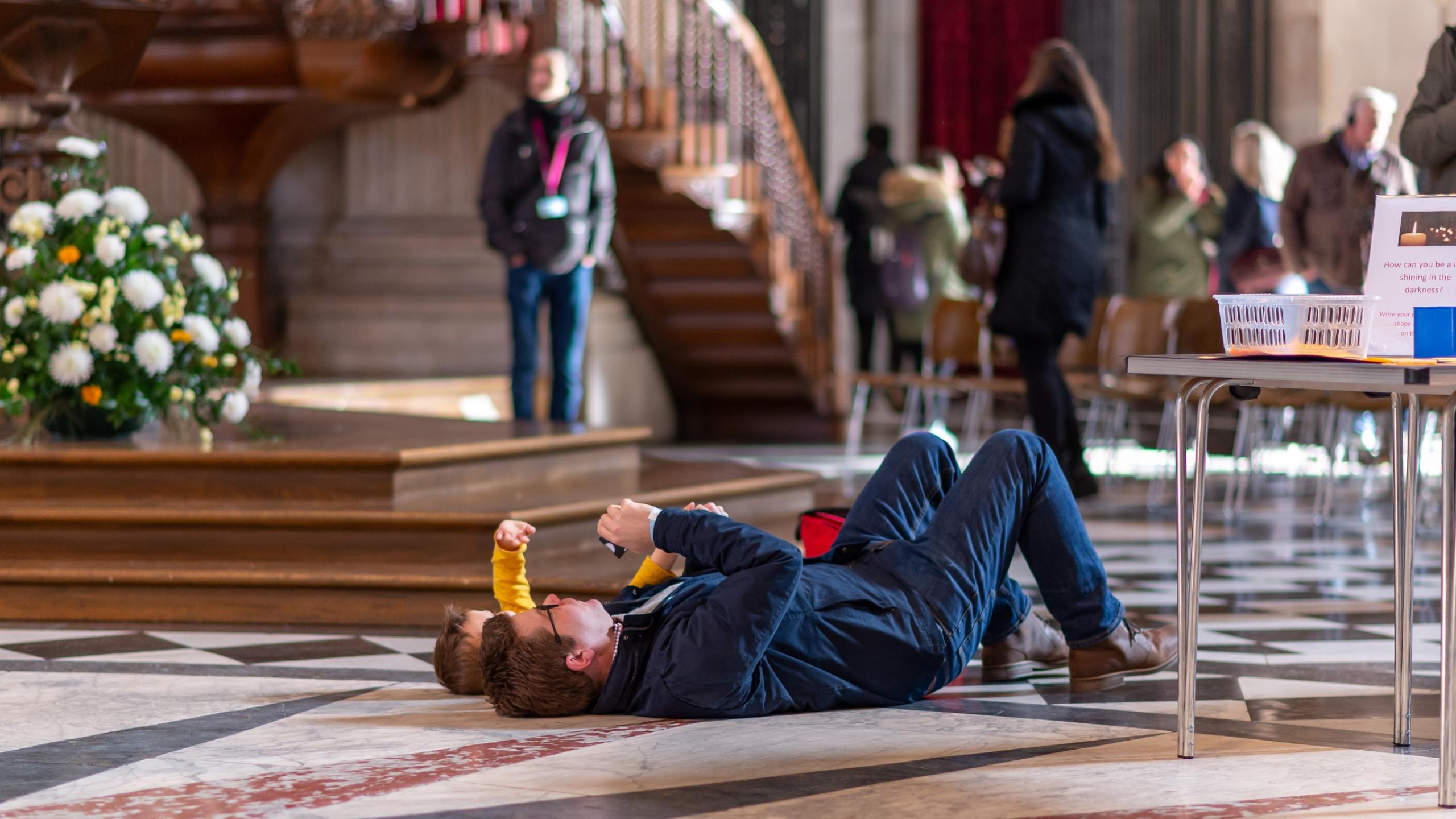 father and child lying down looking up at the Dome ceilling