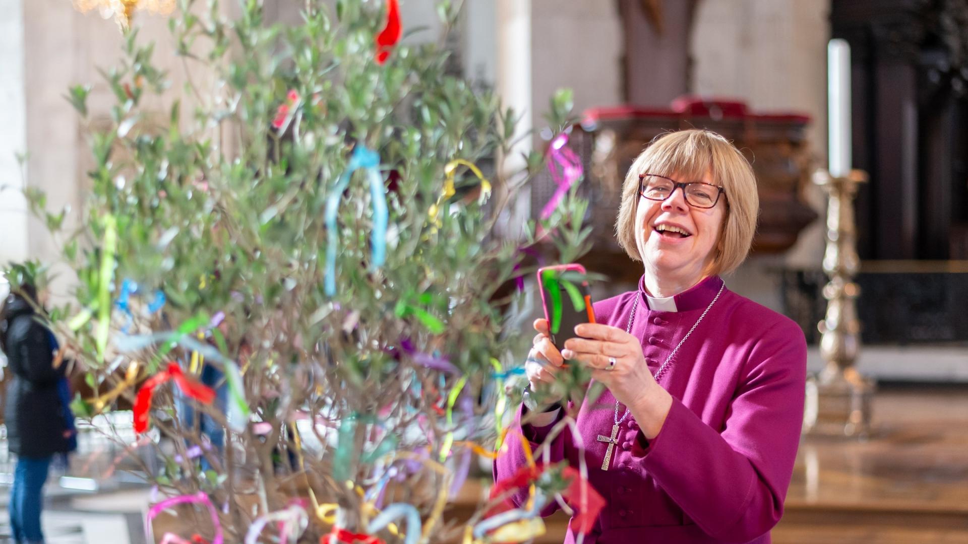 bishop sarah mullally smiling with tree at messy cathedral event