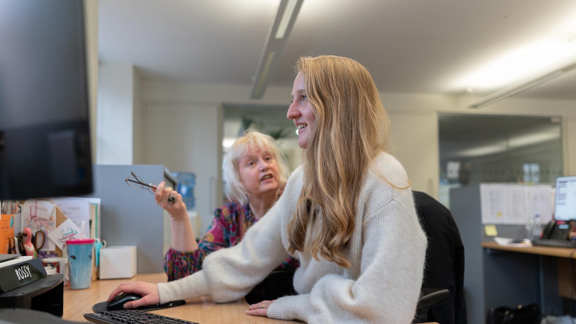 members of staff chatting at desk
