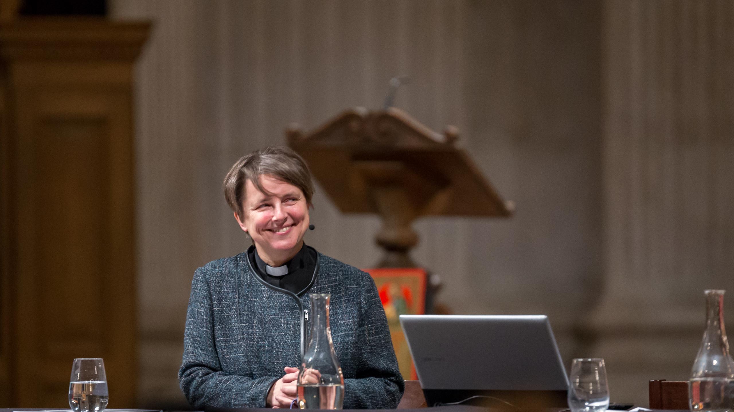 Lucy Winkett smiling on stage at an Adult Learning event in St Paul's Cathedral