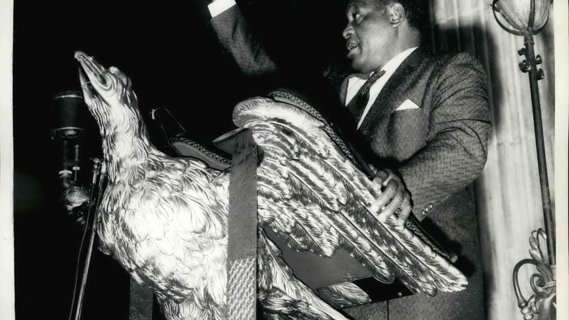 Paul Robeson standing at the eagle lectern, 10 October 1958