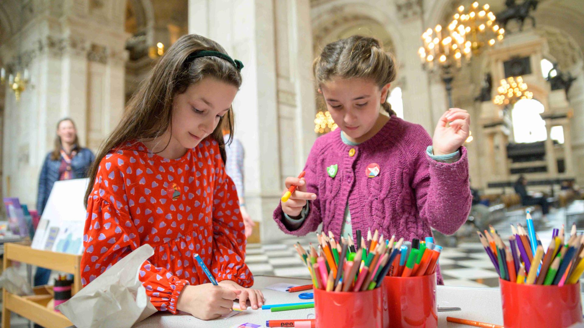 Two young children making badges inside St Paul's Cathedral