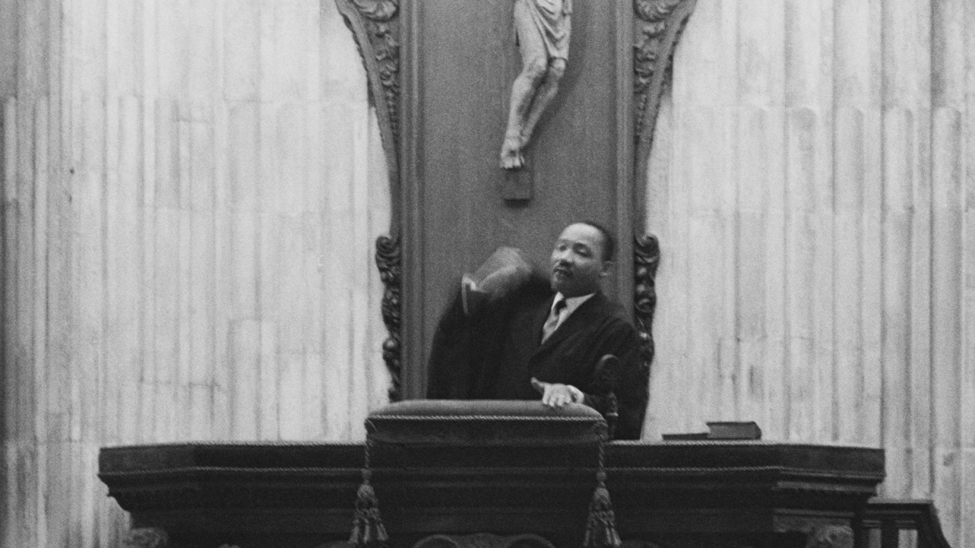 a black and white photograph of Dr Martin Luther King Jr preaching from the pulpit at St Paul's Cathedral