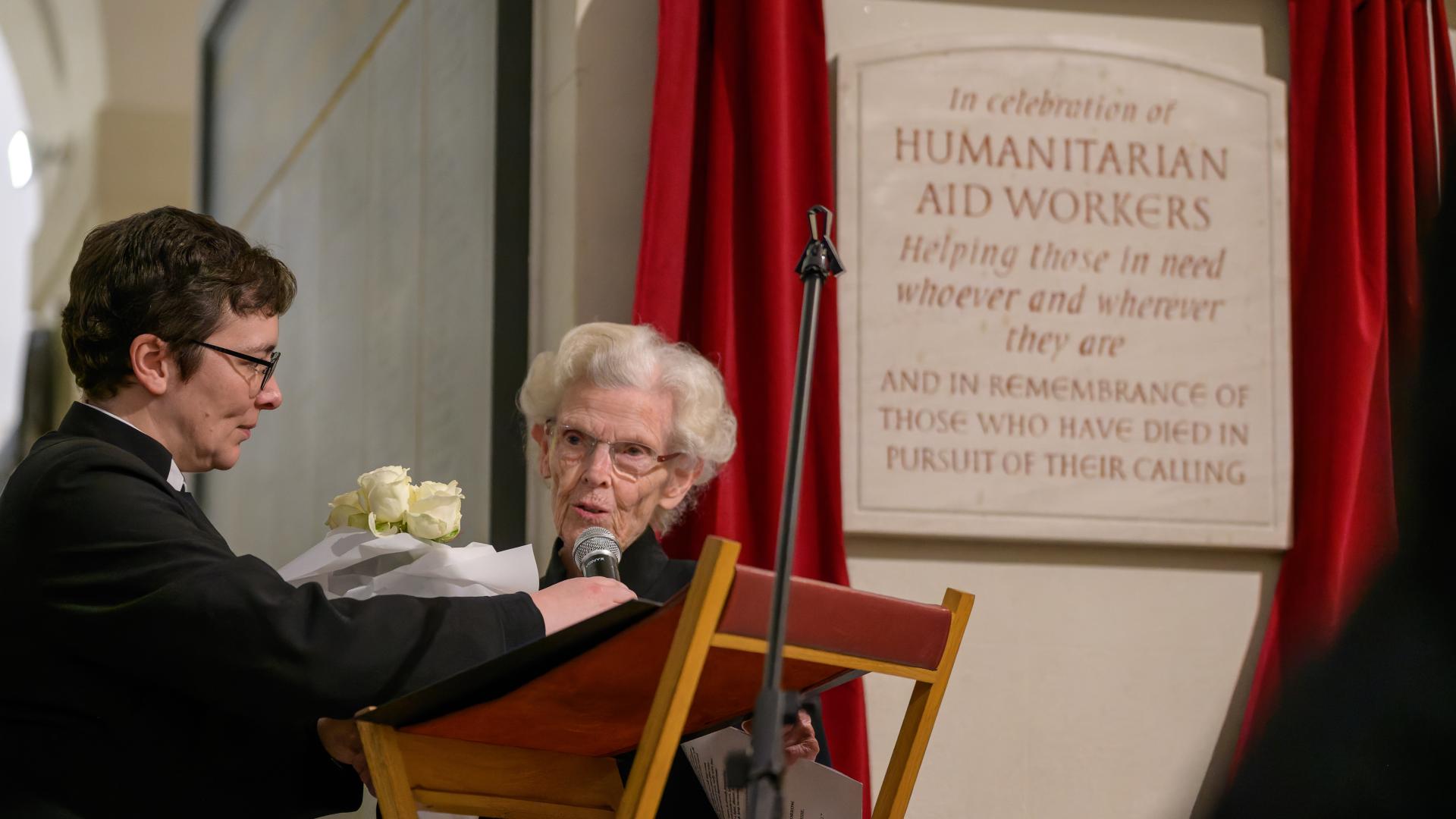 A photo of a new plaque being unveiled in the Crypt of St Paul's Cathedral, with two women standing in front.