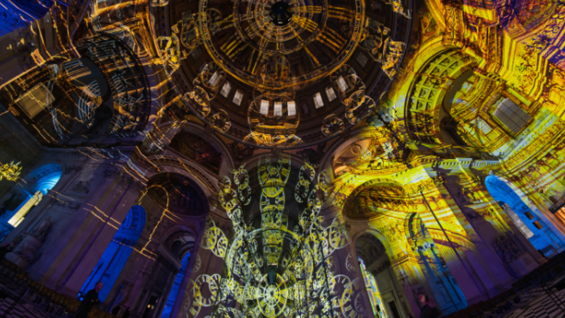 A wide angled shot of the dome and nave, projected with clock designs in purple and gold.