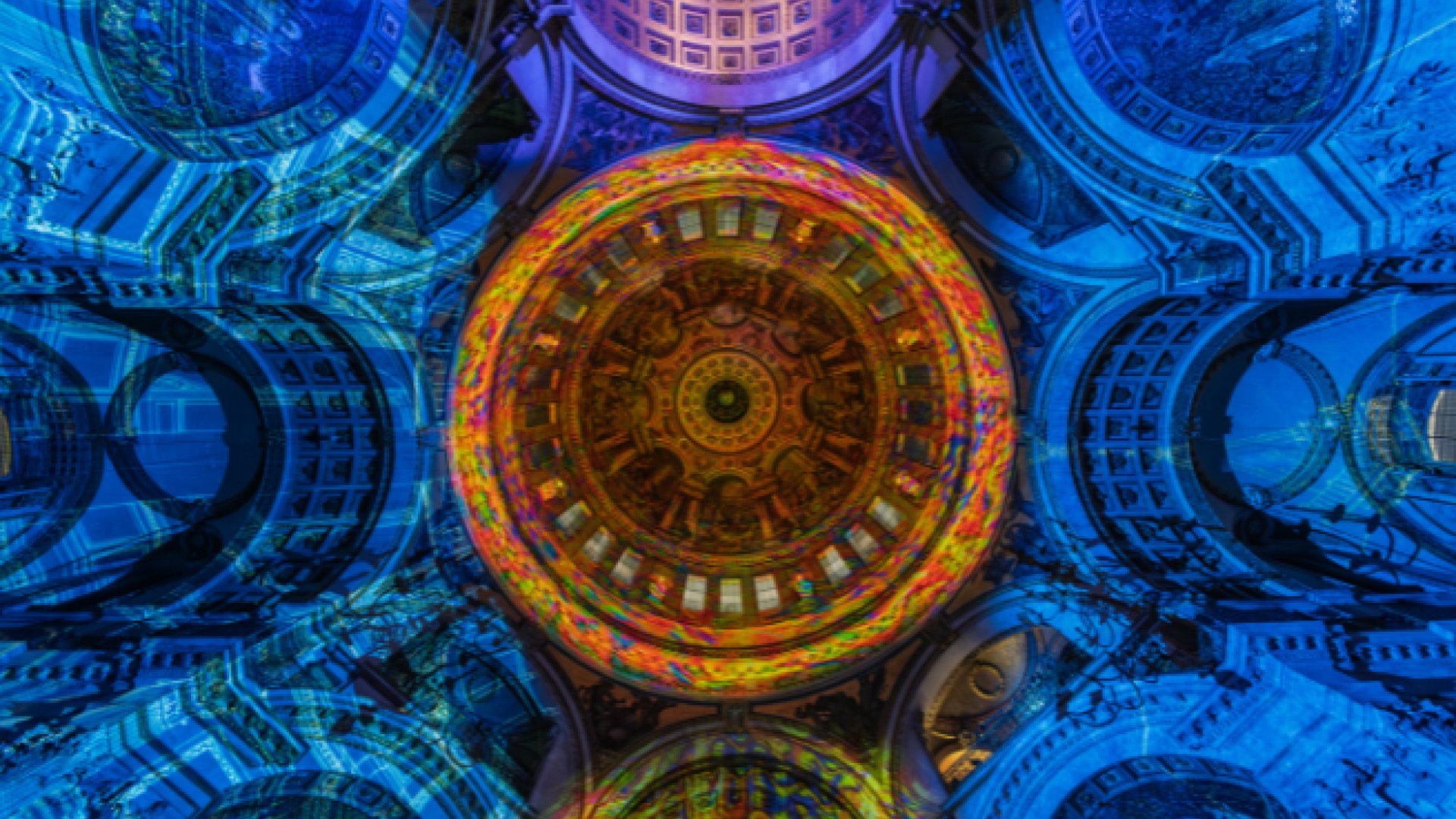 The dome of St Paul's lit with an orange pattern, surrounded by blue walls.