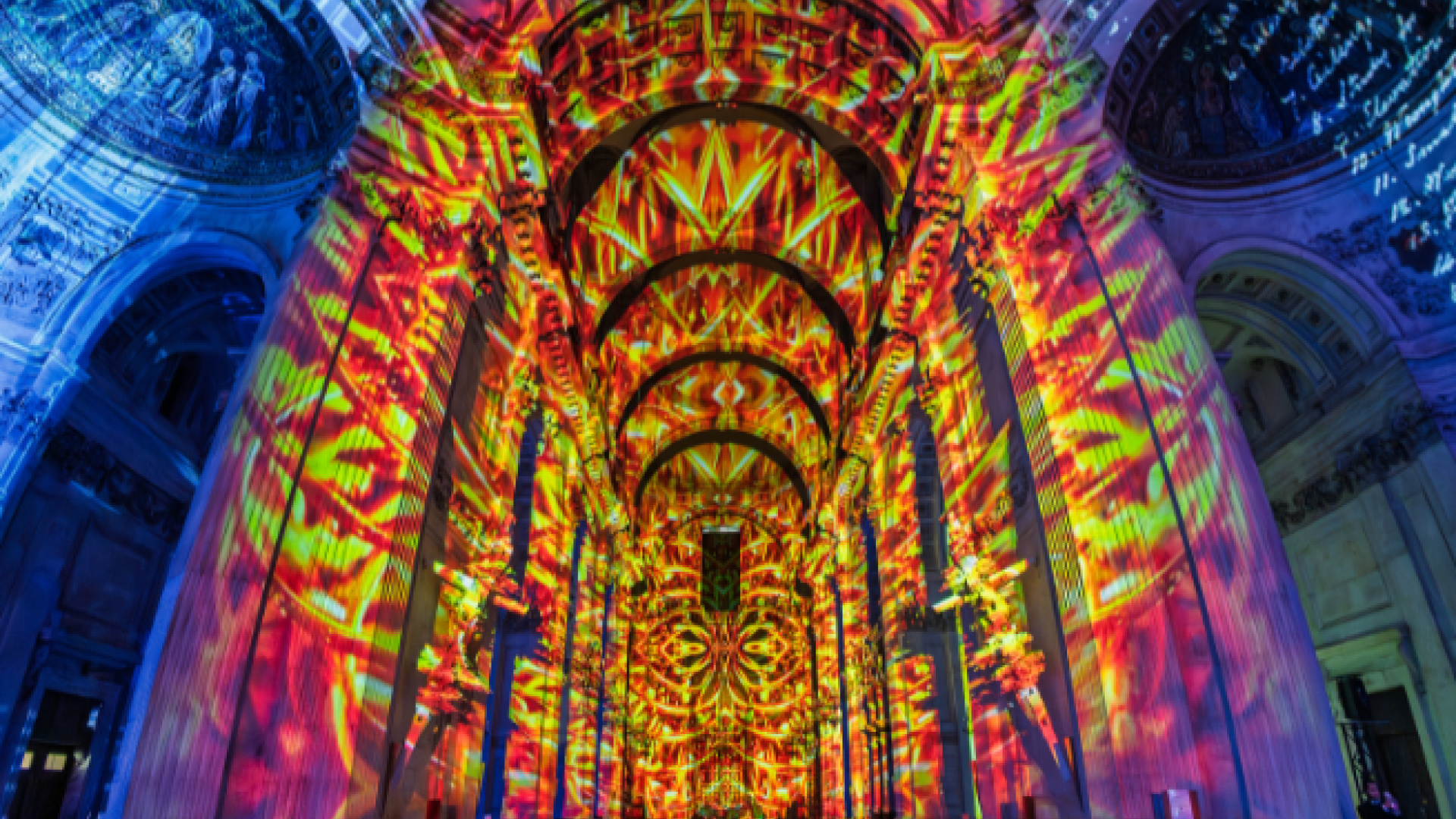The nave of St Paul's, with a projection of red and orange flames depicting the Great Fire. On each side the walls are blue.