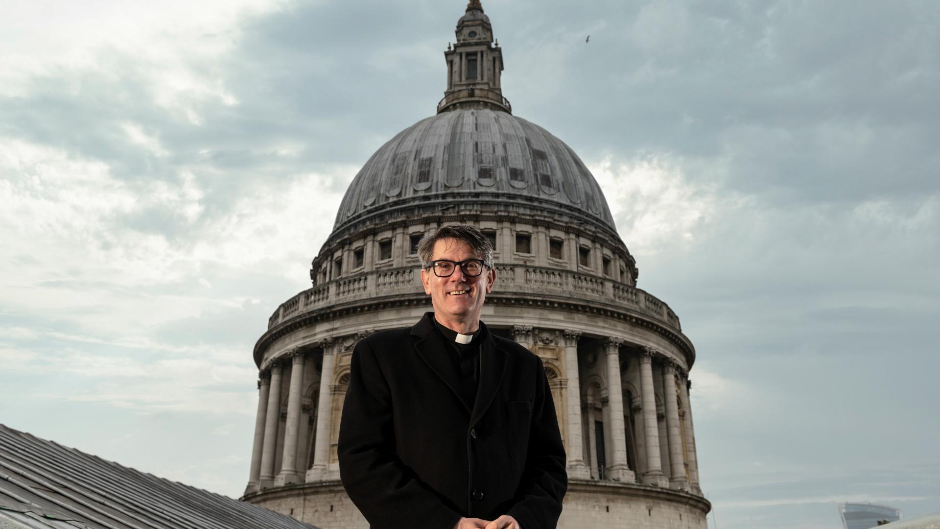 Dean Andrew Tremlett stands on the roof of St Paul's with the Dome behind him.