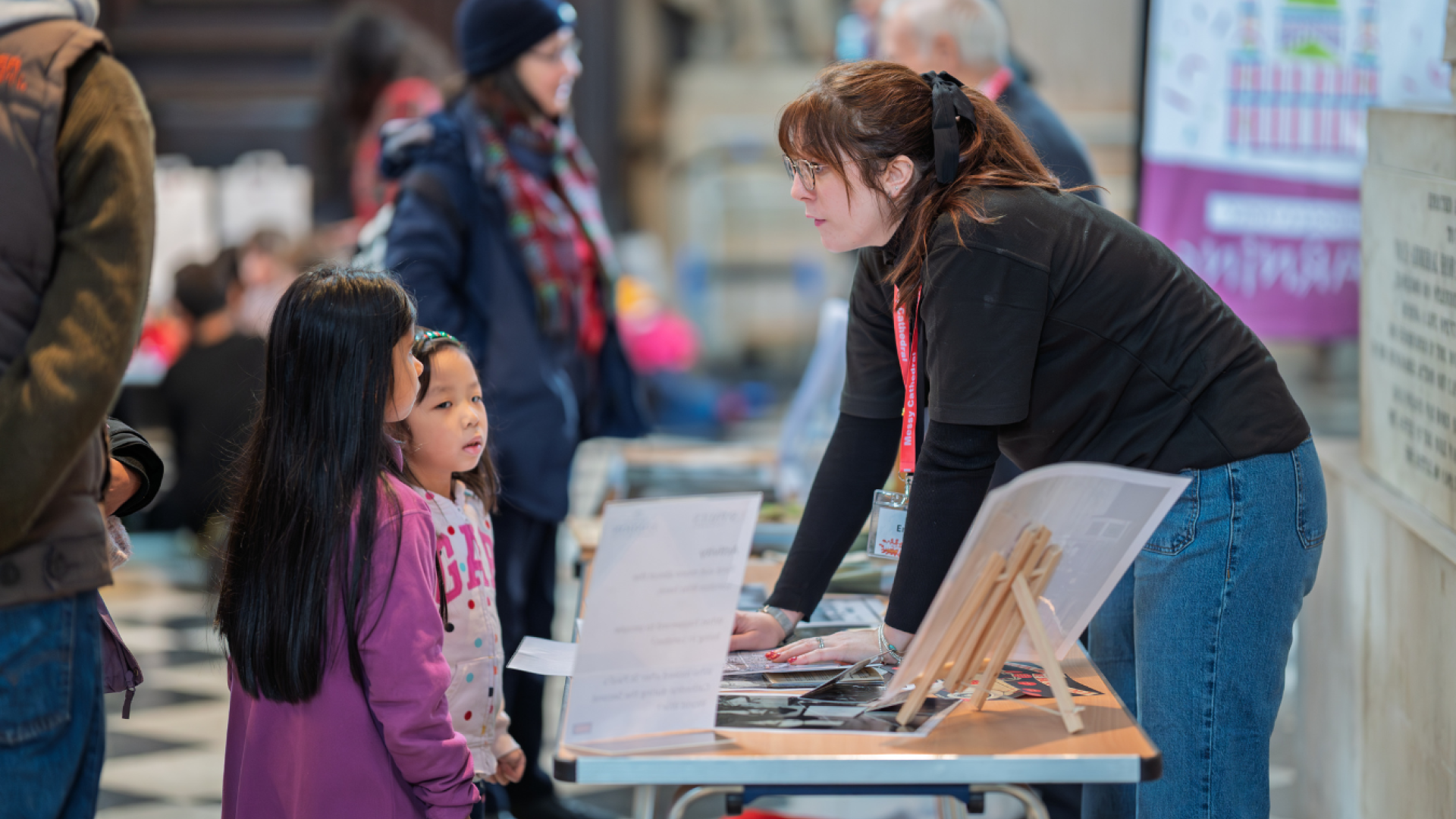Emma, a member of the Learning team, speaks to two children at Messy Cathedral.
