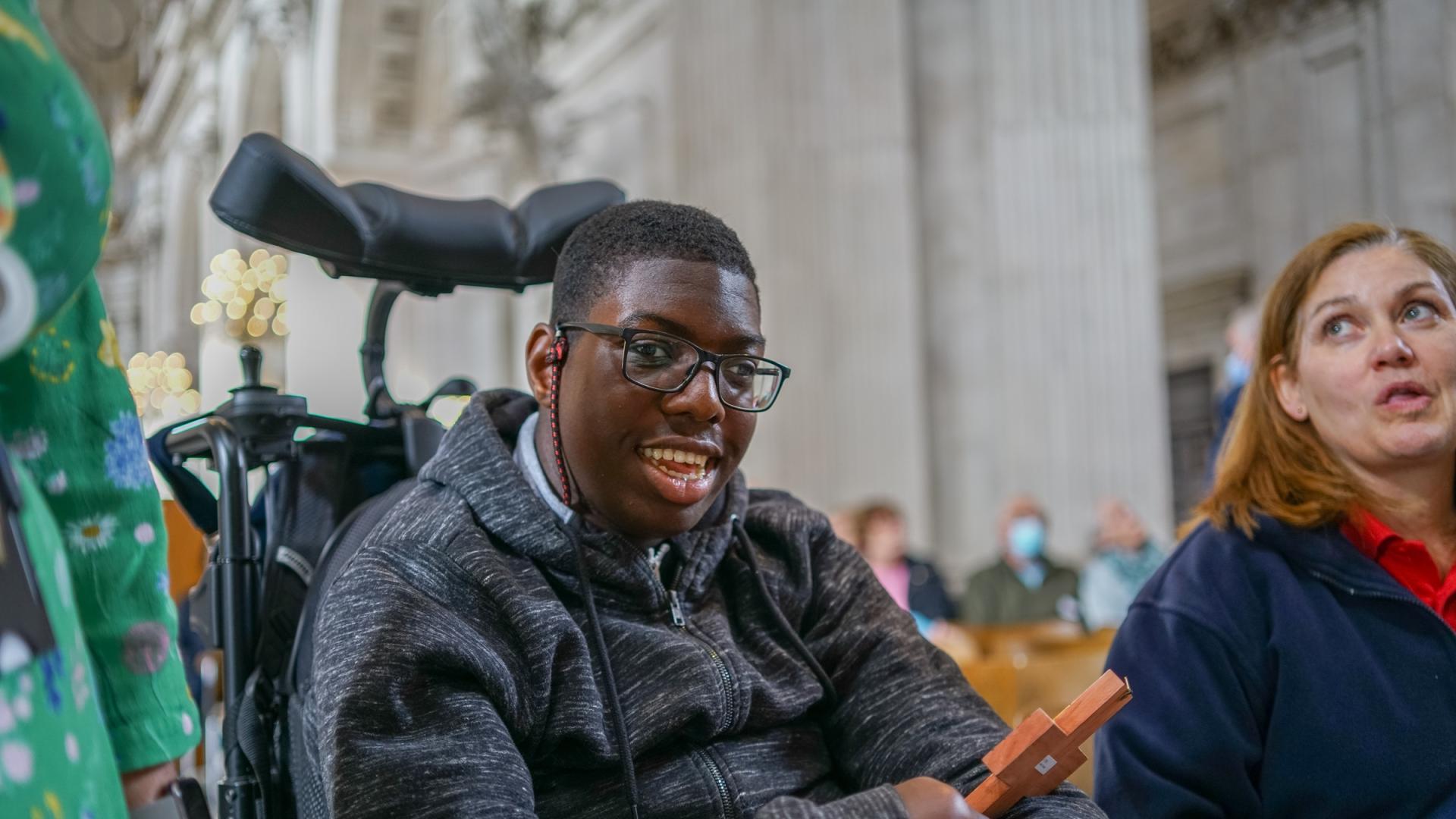 Young person in wheelchair object handling in the cathedral.
