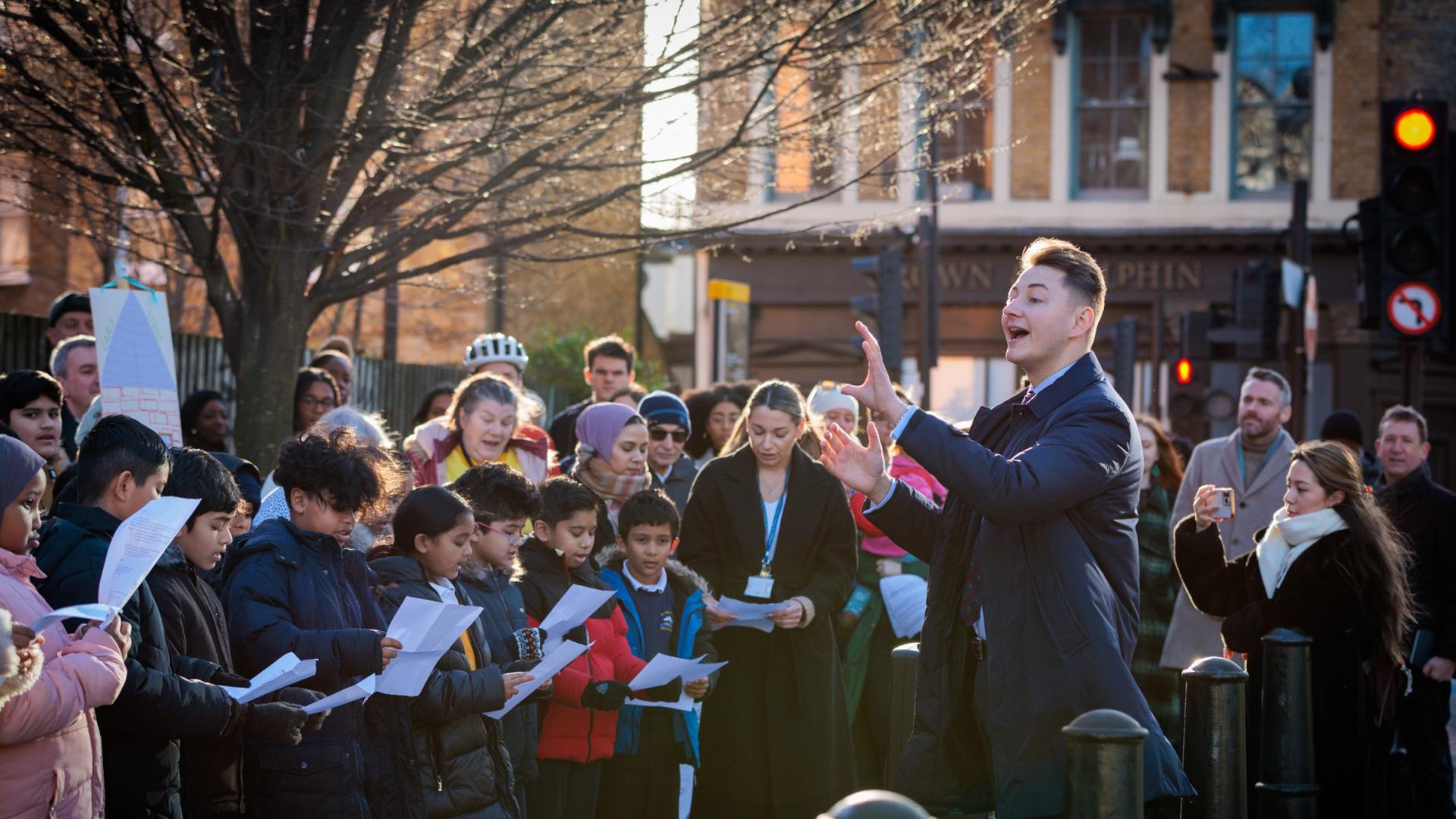 Conductor leading school choir outdoors
