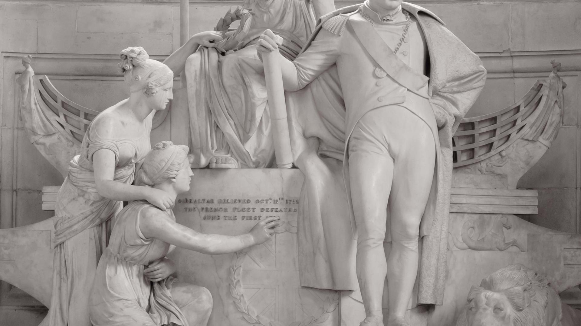 The memorial to Lord Admiral Howe on the Cathedral floor. A white marble statue depicting Howe surrounded by classical style female figures, a boat and a lion.