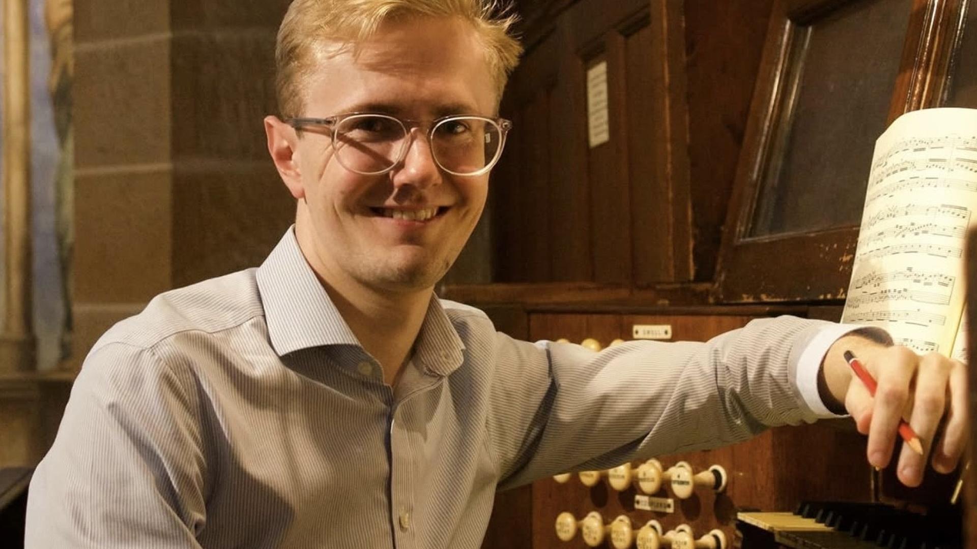 Hamish Wagstaff sits at an organ manual.