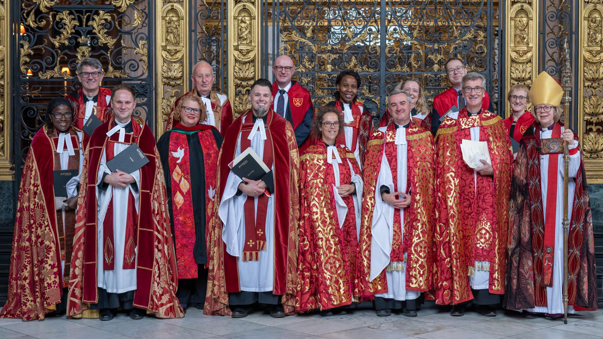Members of the clergy gather for a photo in front of the Quire gate.