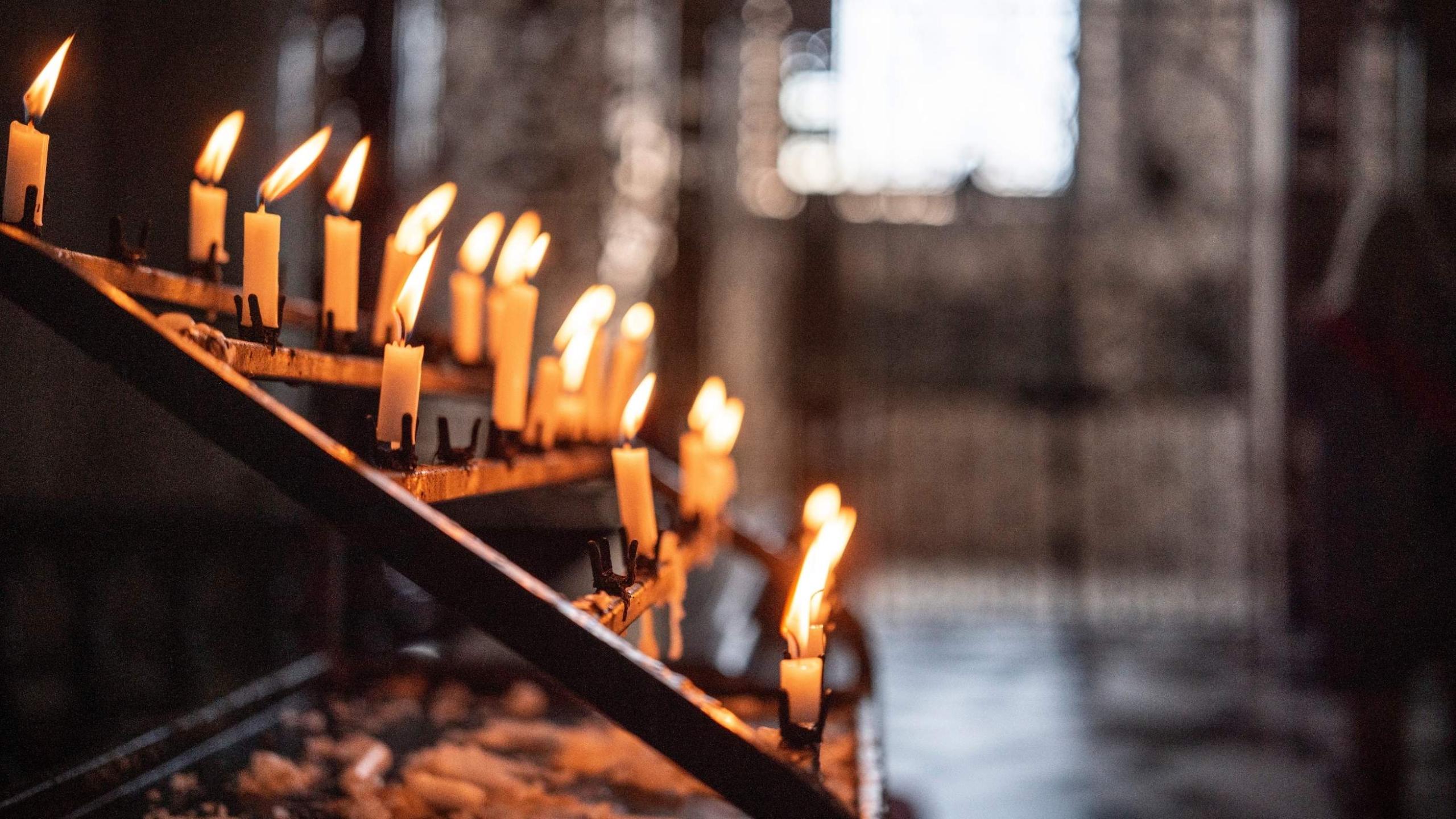 A wrought iron stand of lit candles inside St Paul's Cathedral