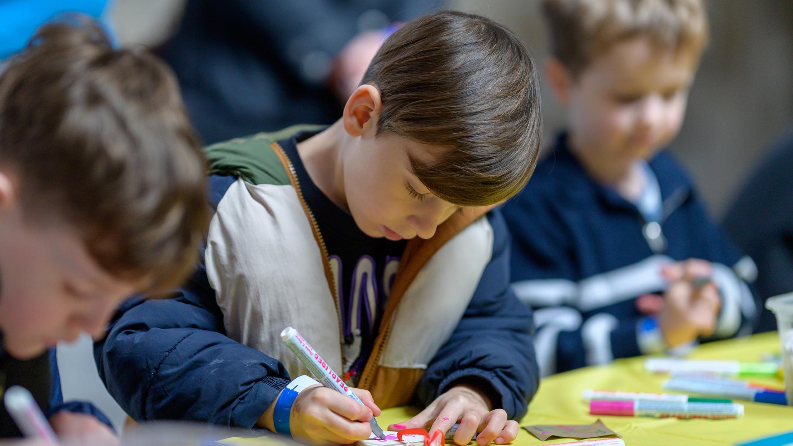 Three children colouring in 