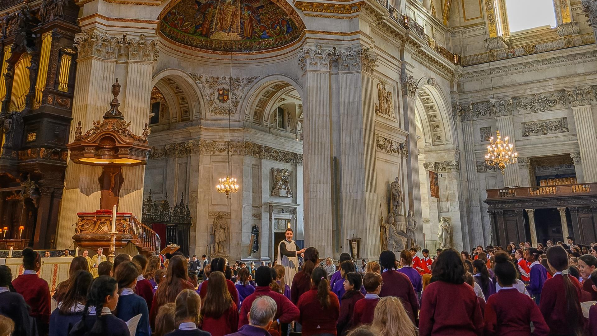 children sitting in seats under the dome with a conductor