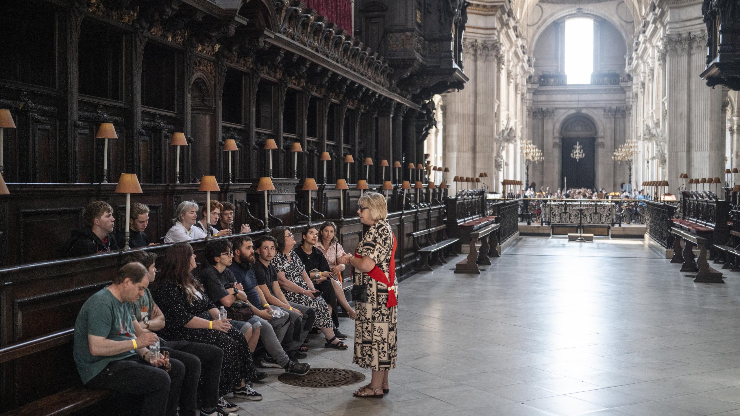 A tour group listens to a guide in the Quire.