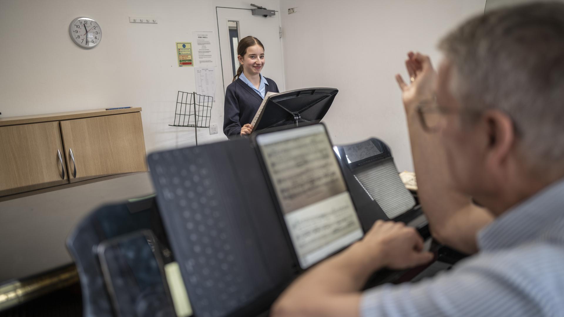 A girl Chorister in a classroom with a teacher for a singing lesson