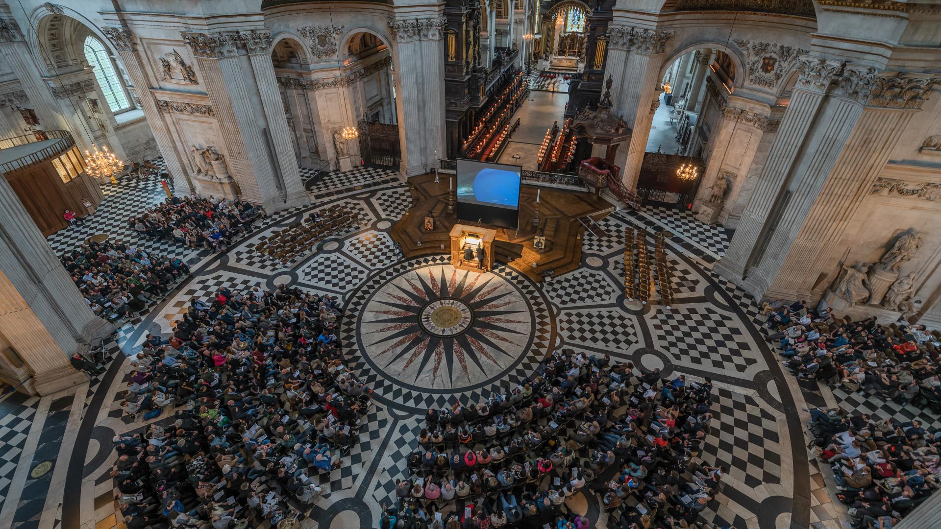 An overhead shot of the Dome area, filled with people in seats around the Grand Organ in the centre.