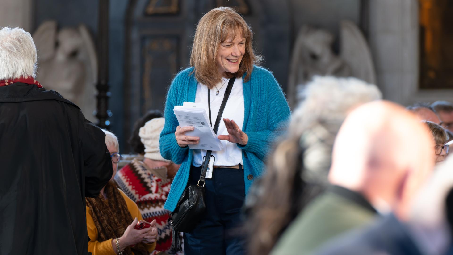 Sarah Holman, a volunteer with the St Paul's Cathedral Institute, speaks to visitors at an event.