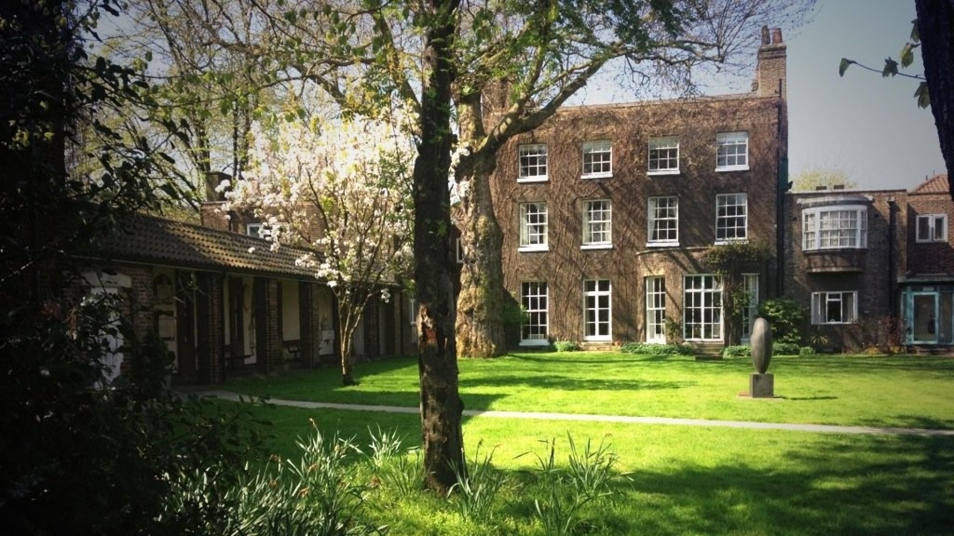 The garden at St Katharine's with trees in the foreground and a large green lawn