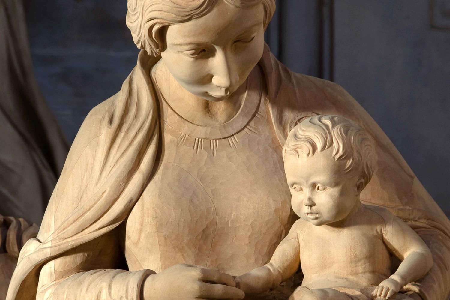 A wooden carved nativity scene with Mary and Baby Jesus