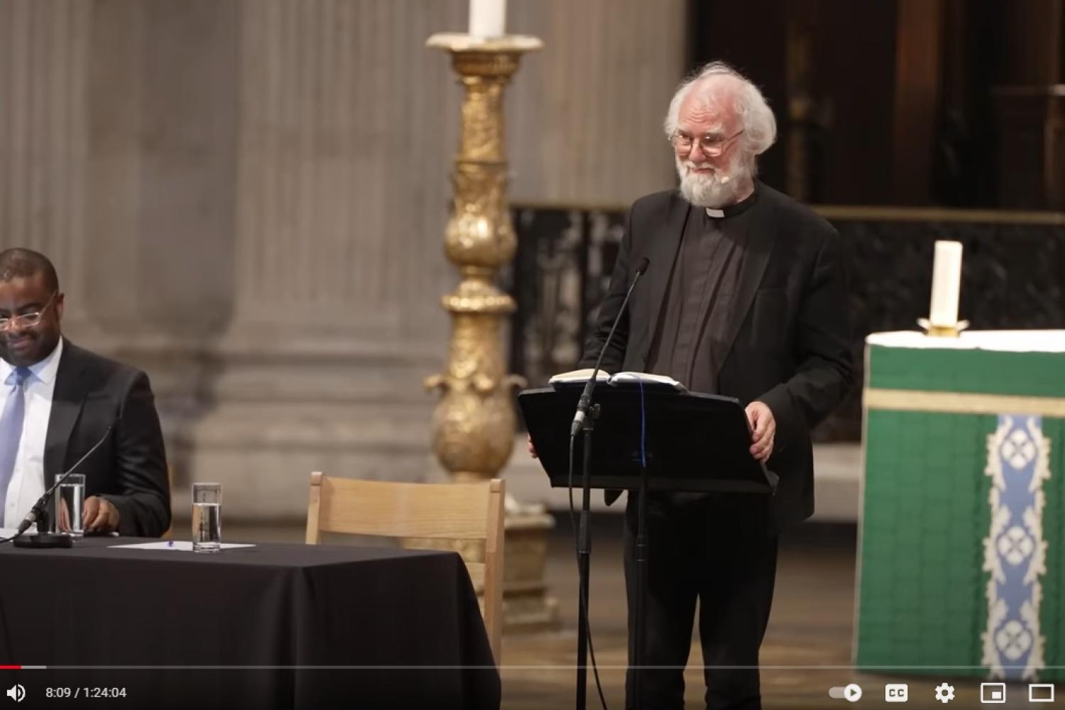 Rowan Williams stands at a lectern on stage at St Paul's Cathedral