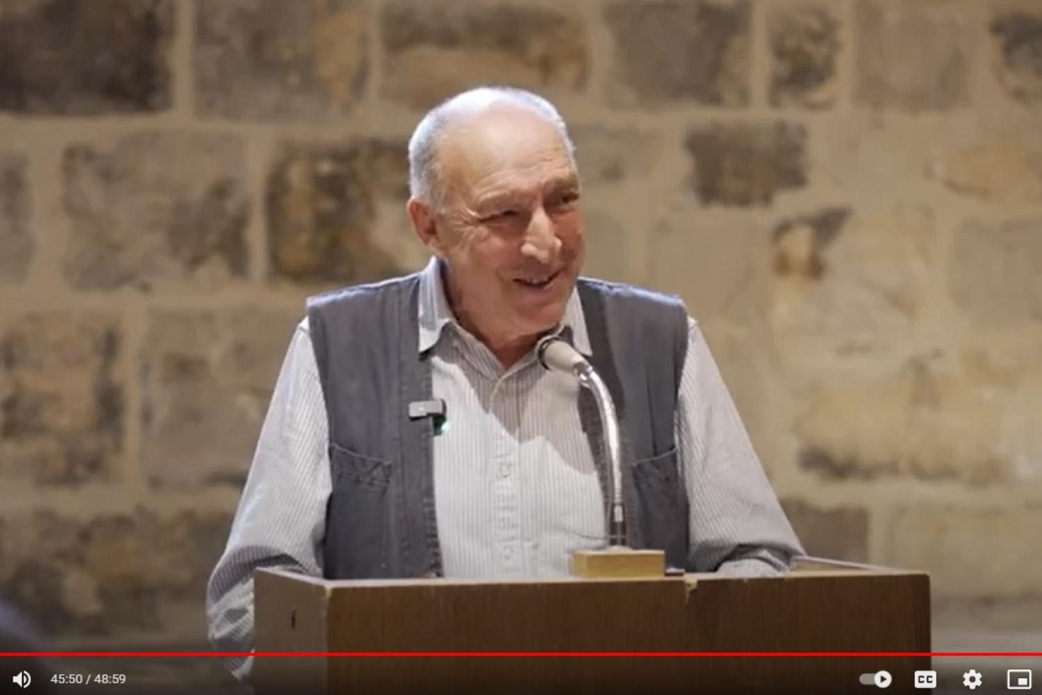 Bob Gilbert, a white man with short grey hair, wearing a white shirt and a grey waistcoat, talks in the Wren Suite at St Paul's