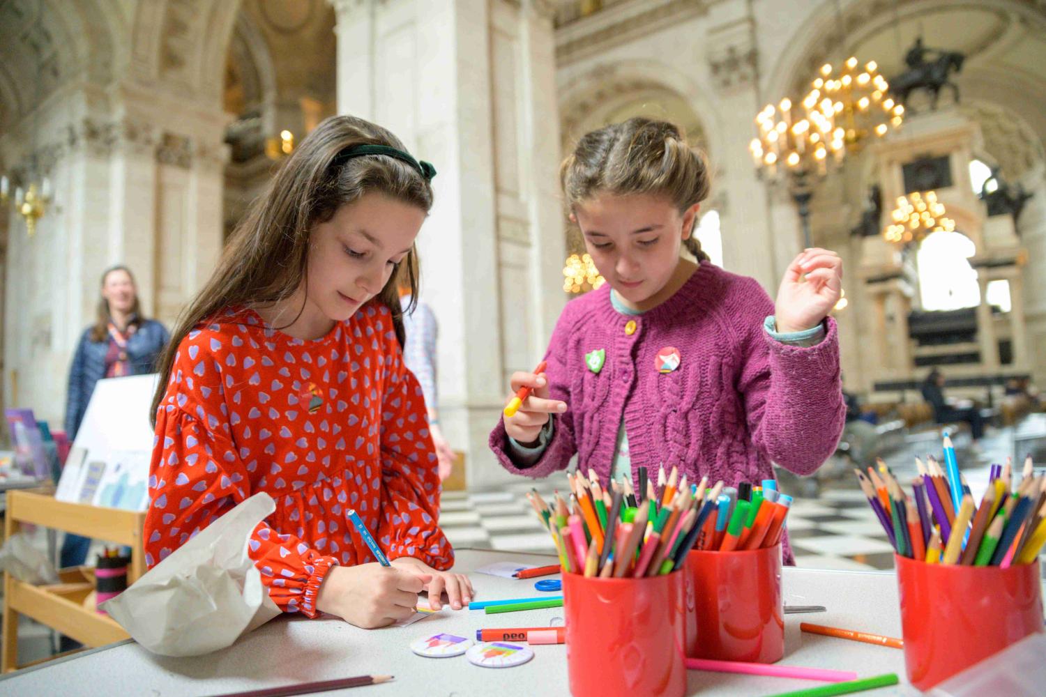 Two young children making badges inside St Paul's Cathedral