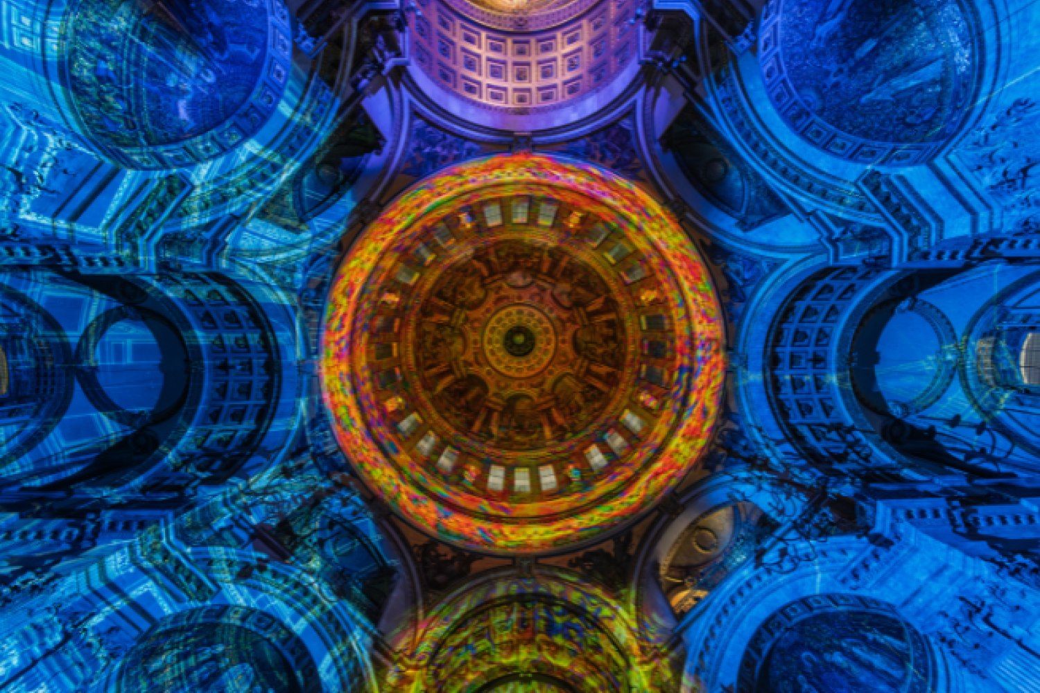 The dome of St Paul's lit with an orange pattern, surrounded by blue walls.