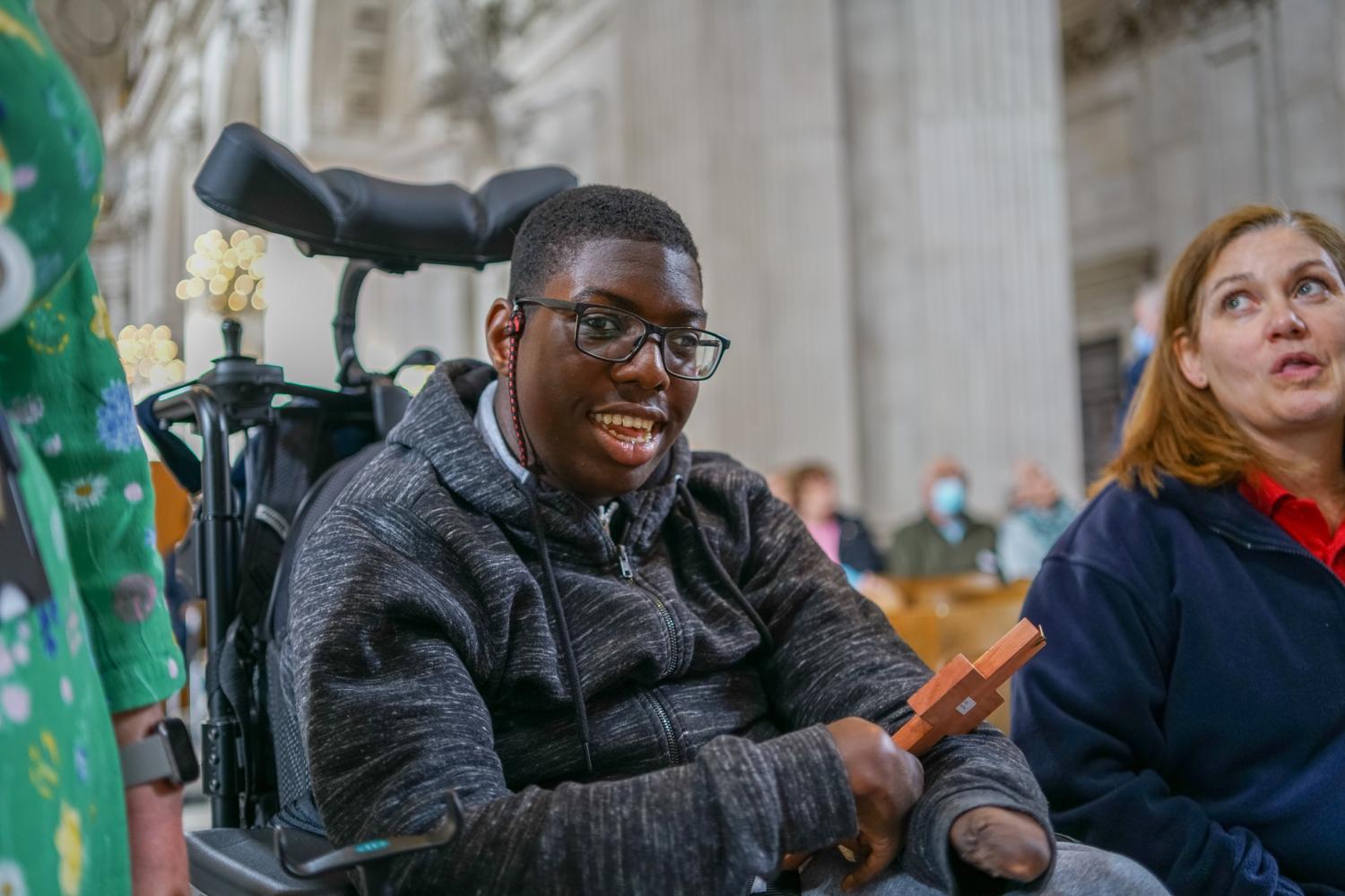 Young person in wheelchair object handling in the cathedral.