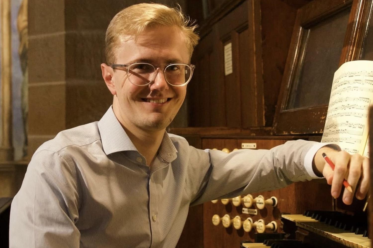 Hamish Wagstaff sits at an organ manual.