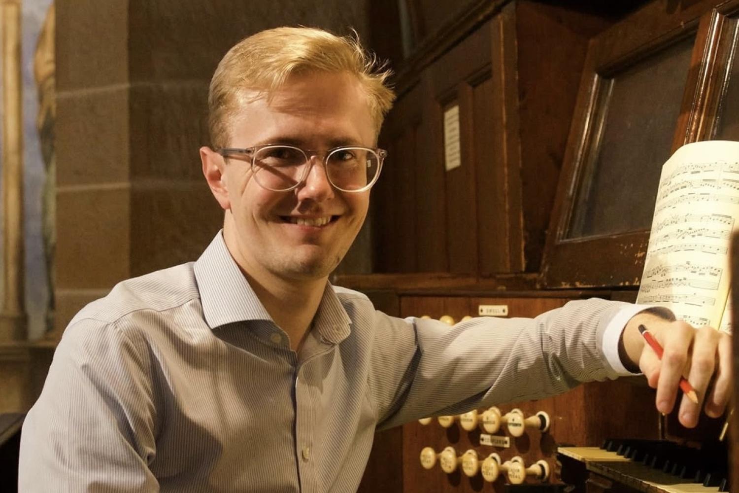 Hamish Wagstaff sits at an organ manual.