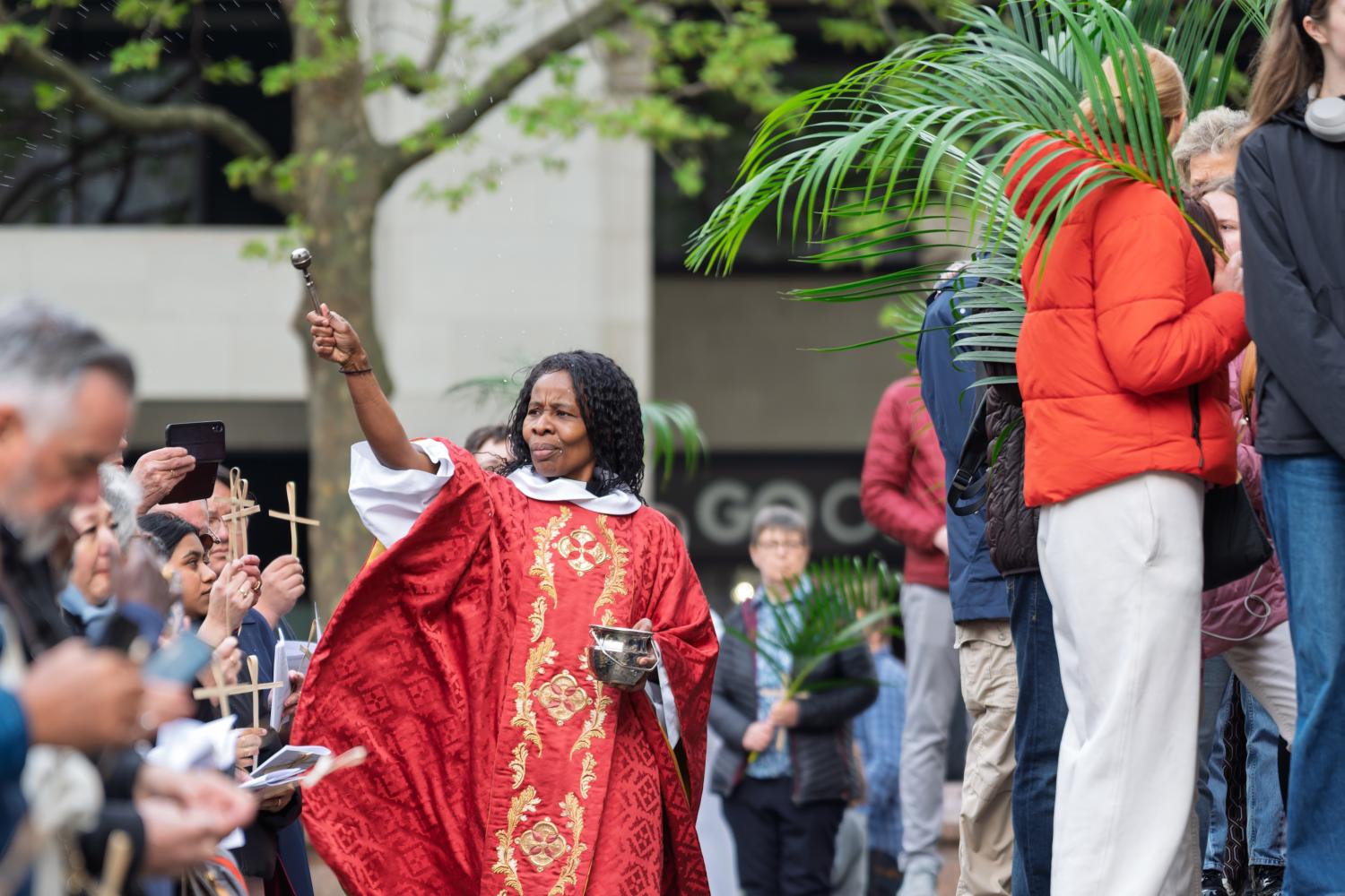 Canon Steward Catherine Okoronkwo blesses the crowd on the West Steps on Palm Sunday.