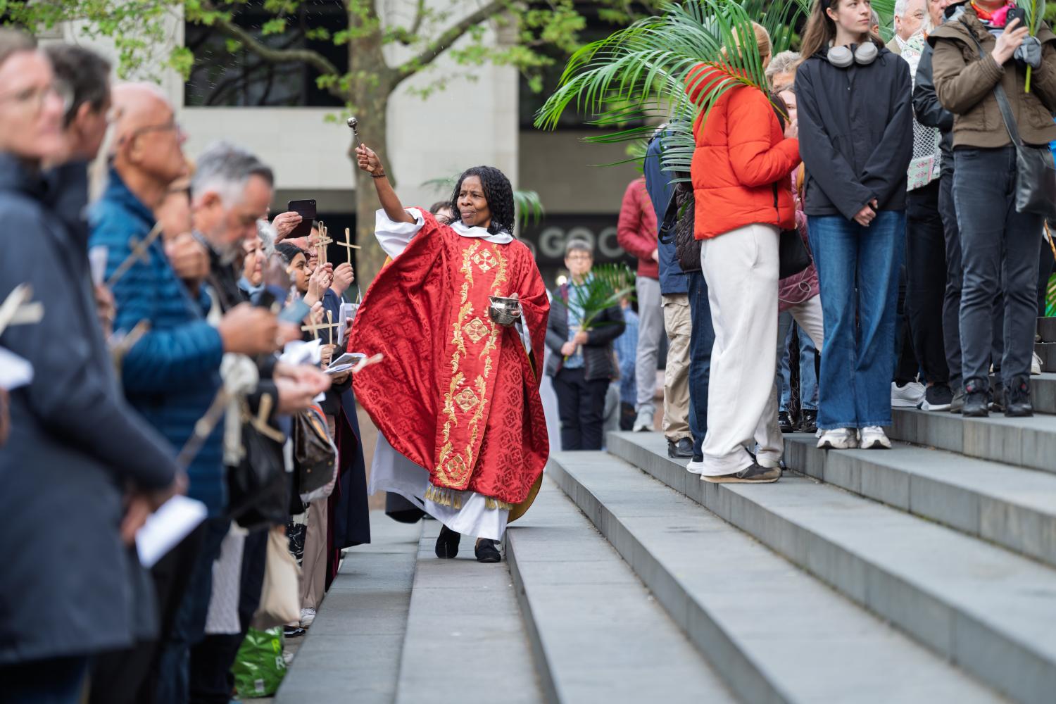 Canon Steward Catherine Okoronkwo blesses the crowd on the West Steps on Palm Sunday.