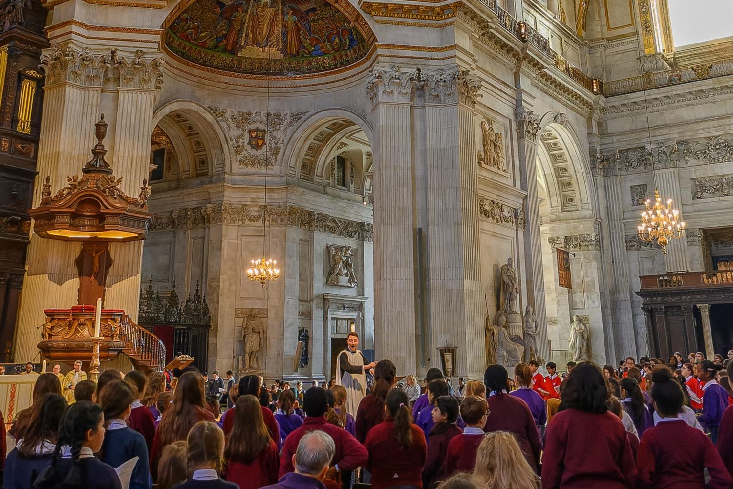 children sitting in seats under the dome with a conductor