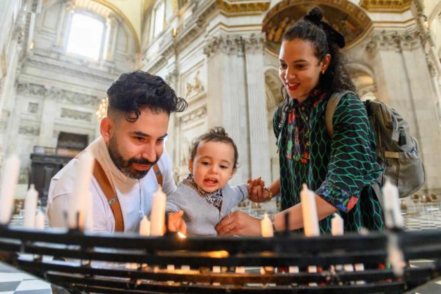 young family with candles in the cathedral