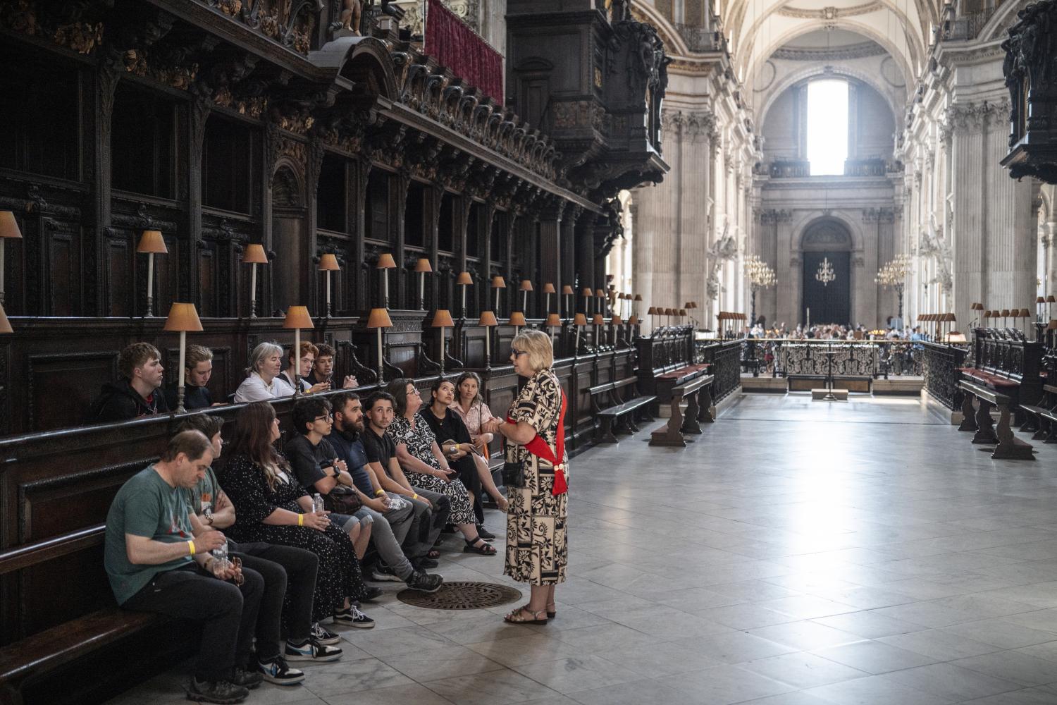 A tour group listens to a guide in the Quire.