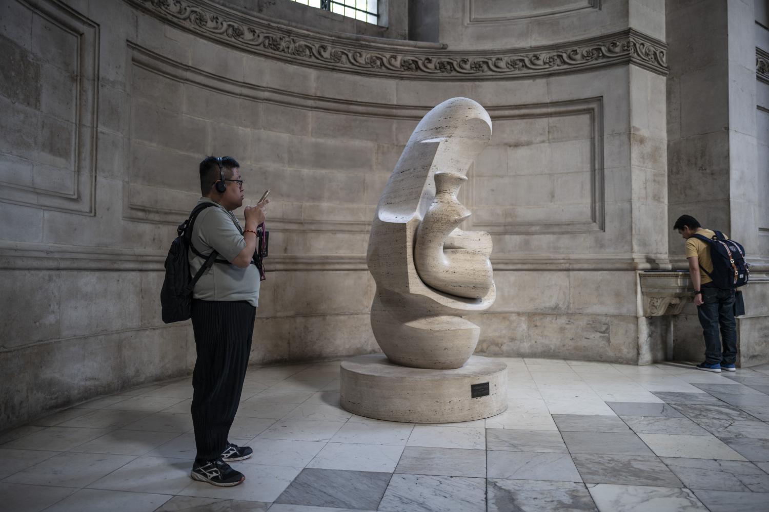 A visitor photographs Mother and Child: Hood by Henry Moore.