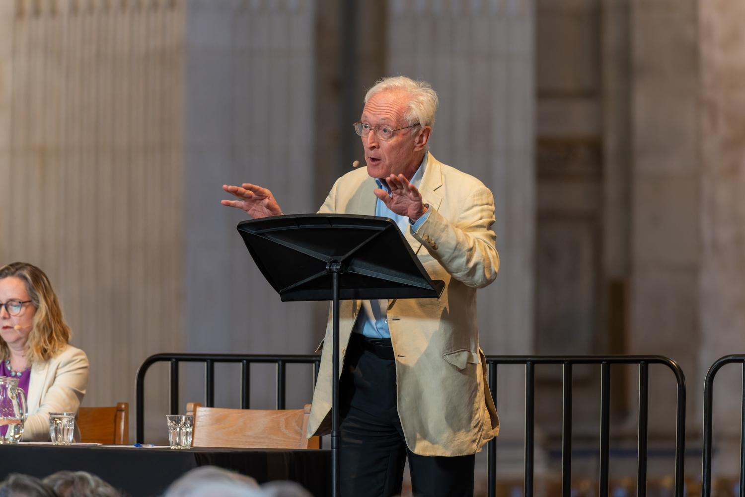 Diarmaid stands at a lectern in St Paul's Cathedral, arms raised as he talks