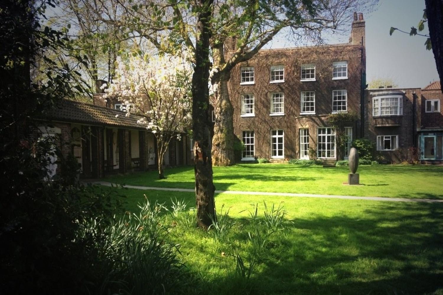 The garden at St Katharine's with trees in the foreground and a large green lawn