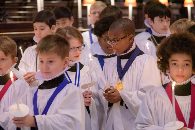 choristers boys sharing candle light christmas