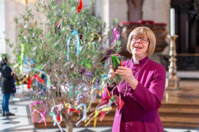 bishop sarah mullally smiling with tree at messy cathedral event